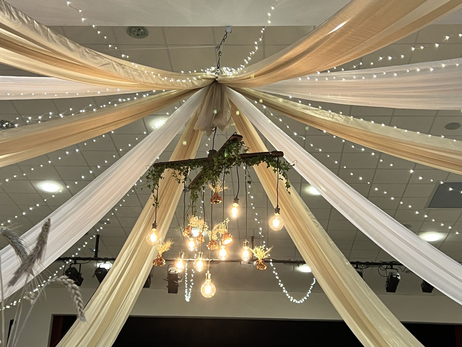 Mariage Espace Galerne plafond tentures blanches et sables structures bois feuillage et ampoules guinguette et vase pampas