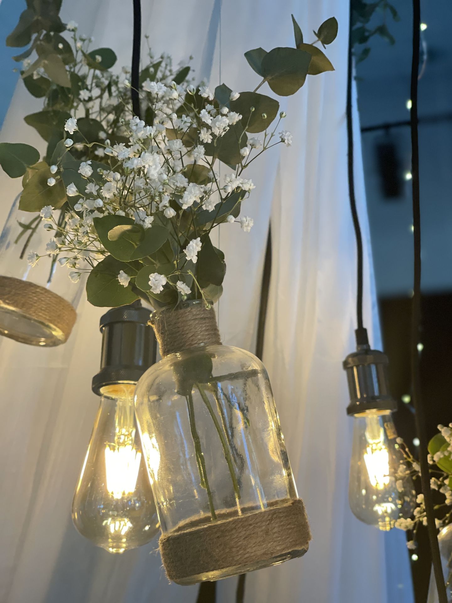 Mariage Espace Galerne plafond tentures blanches leds et structure bois feuillage ampoule guinguette et vase fleuris