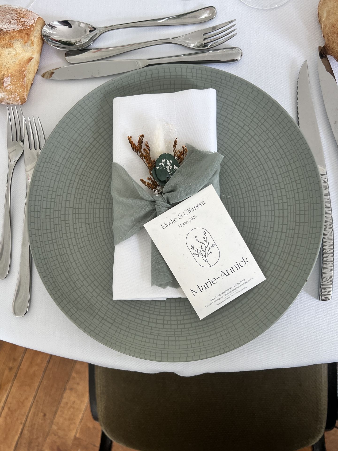 Mariage Château de la Forêt assiette vert sauge serviette blanche noued vert sauge fleurs sèches marque place personnalisé