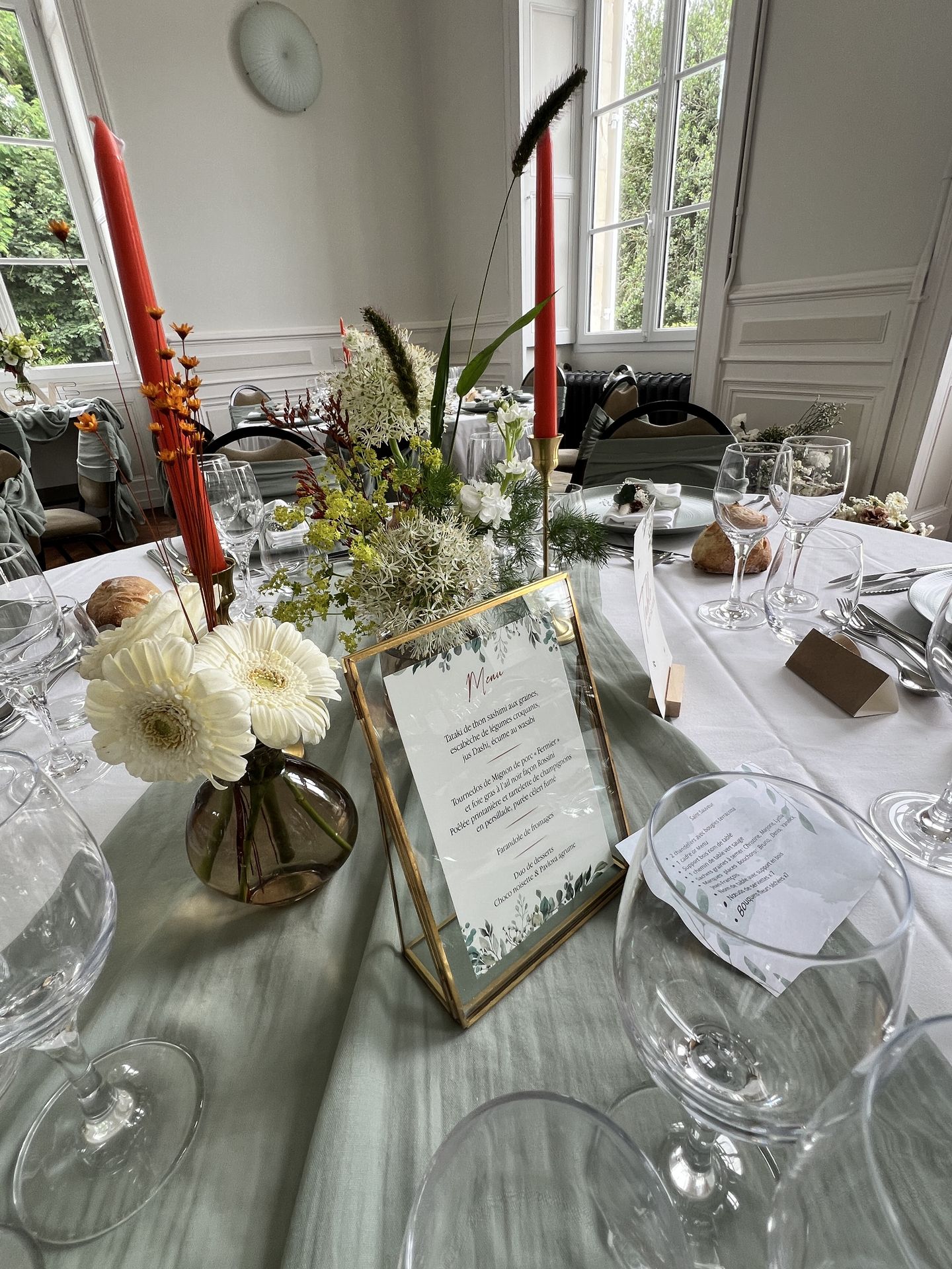 Mariage Château de la Forêt table blanche et vert sauge bougie orange cadre menu dorée composition florales blanche
