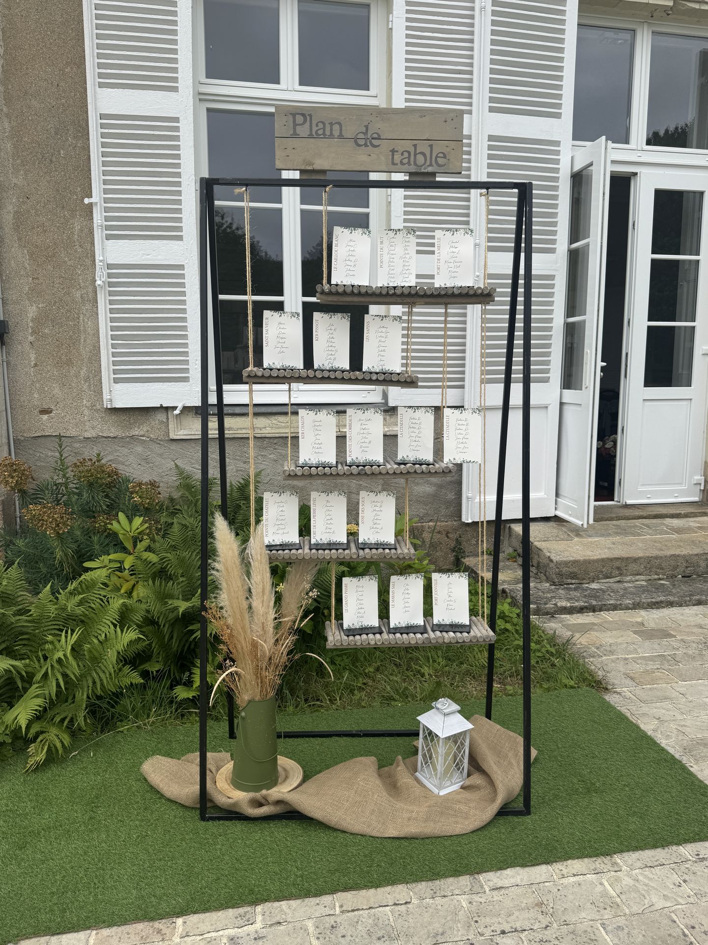 Mariage Château de la Forêt plan de table balançoire impression blanche et vert sauge rondin de bois vase pampas lanterne