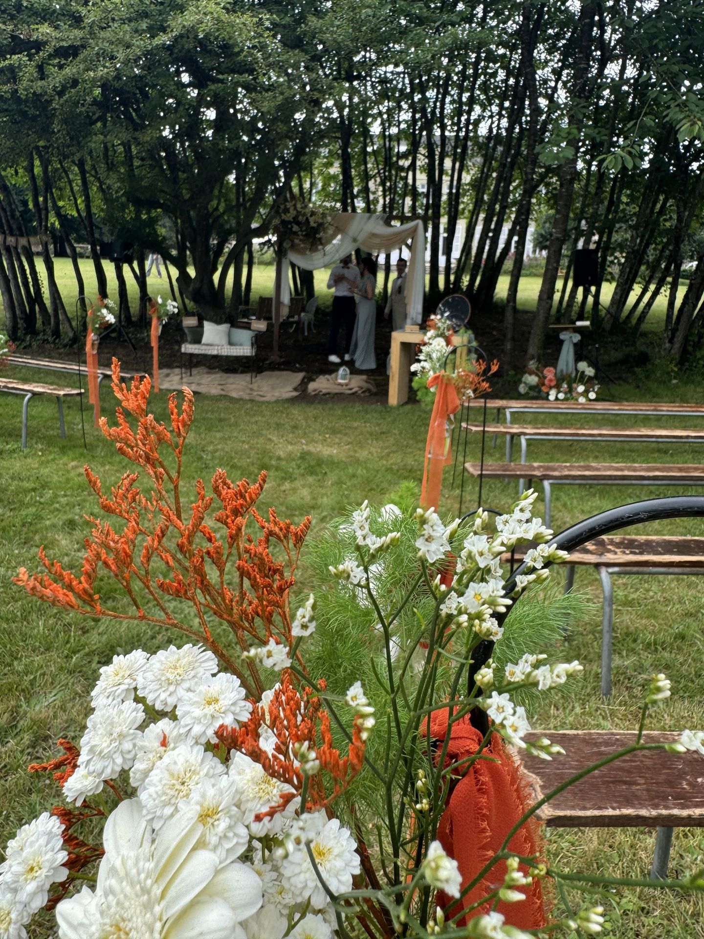 Mariage Château de la Forêt cérémonie laique banc bois noeud tissu orange fleurs blanche