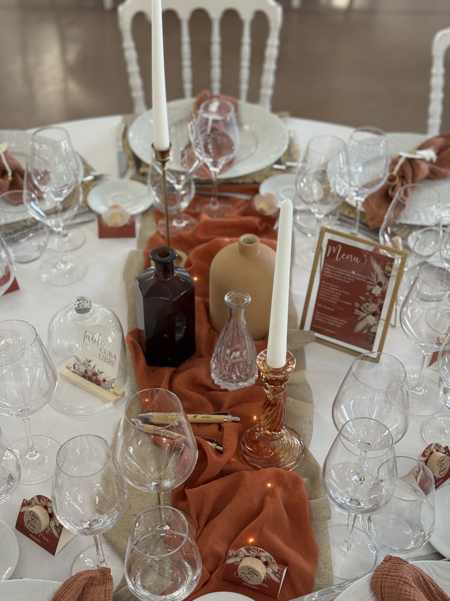 Mariage Domaine de la Jousselinière salle intérieure table blanche serviette terracotta chemin de table sable et terracotta bougie vase naturel