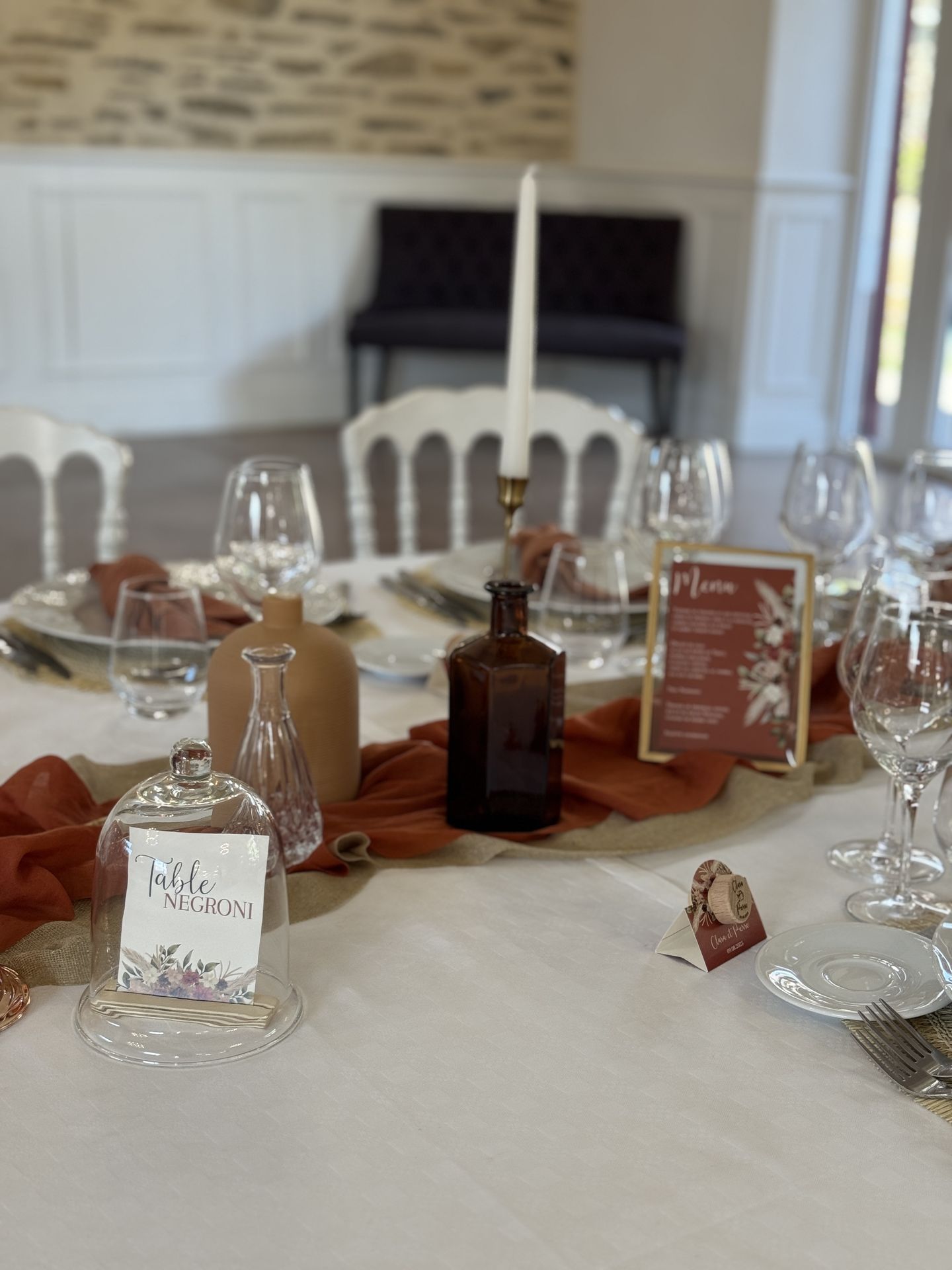 Mariage Domaine de la Jousselinière salle intérieure table blanche serviette terracotta chemin de table sable et terracotta bougie vase naturel