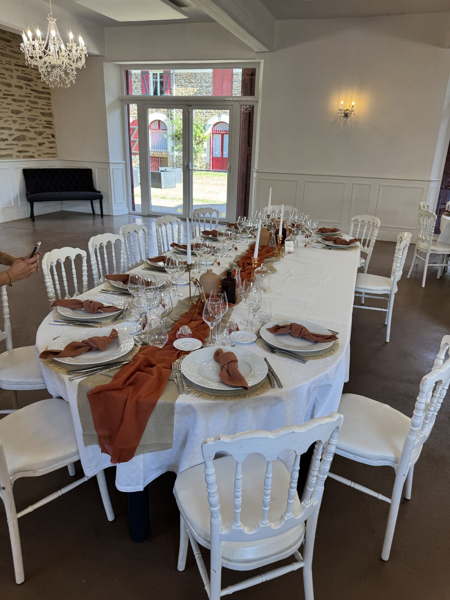 Mariage Domaine de la Jousselinière salle intérieure table blanche serviette terracotta chemin de table sable et terracotta bougie vase naturel