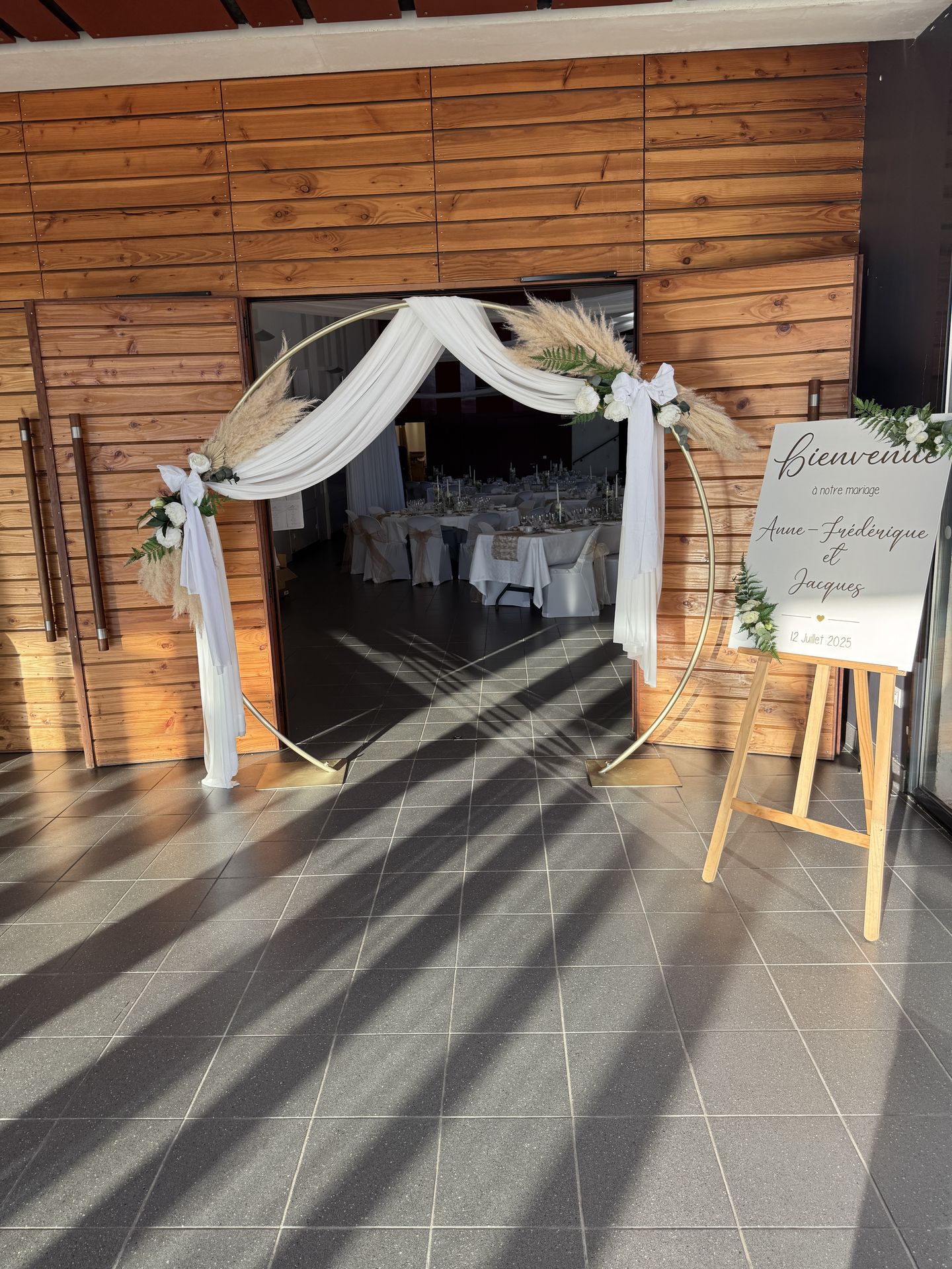 Mariage Espace Convivial Arche ronde doré pampas mousseline blanche panneau bienvenue