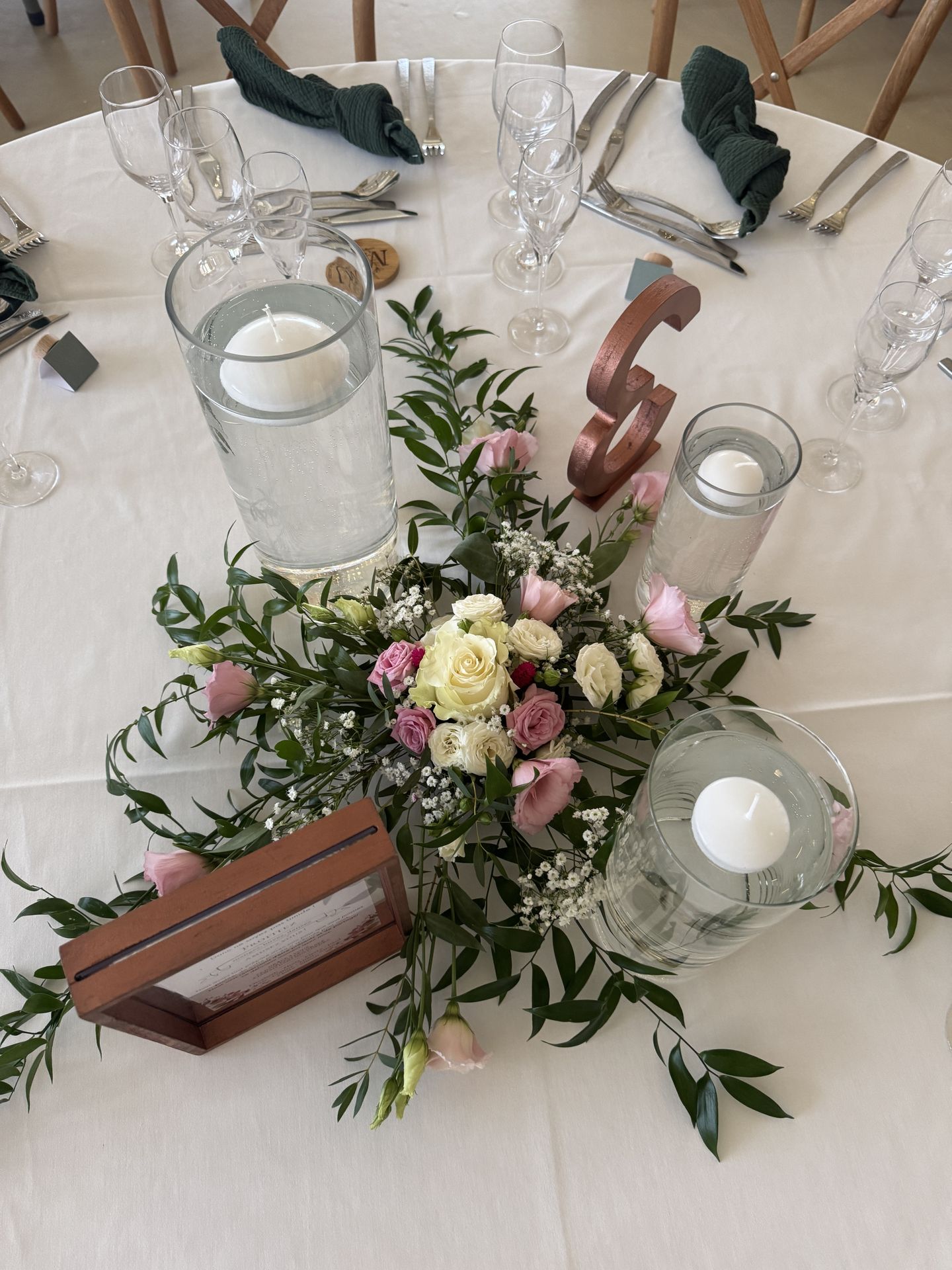 Mariage Domaine 4 Plumes centre de table composition florales rose blanche et feuillaeg bougies blanche vase cadre rose numéro de table rose serviette verte sapin