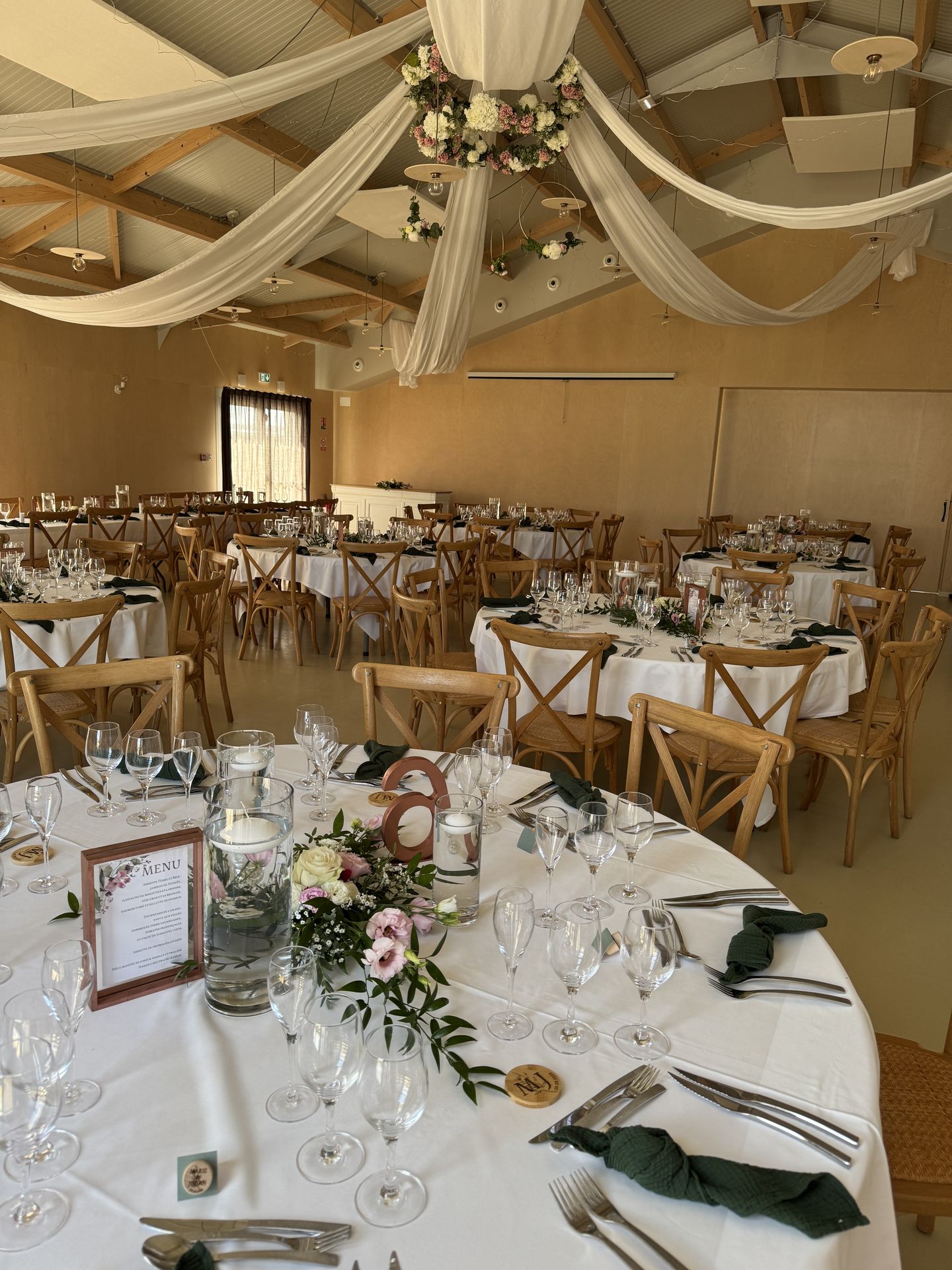 Mariage Domaine 4 Plumes plafond tentures blanches couronne de fleurs leds table blanche composition florales bougies vase chaise bois naturel