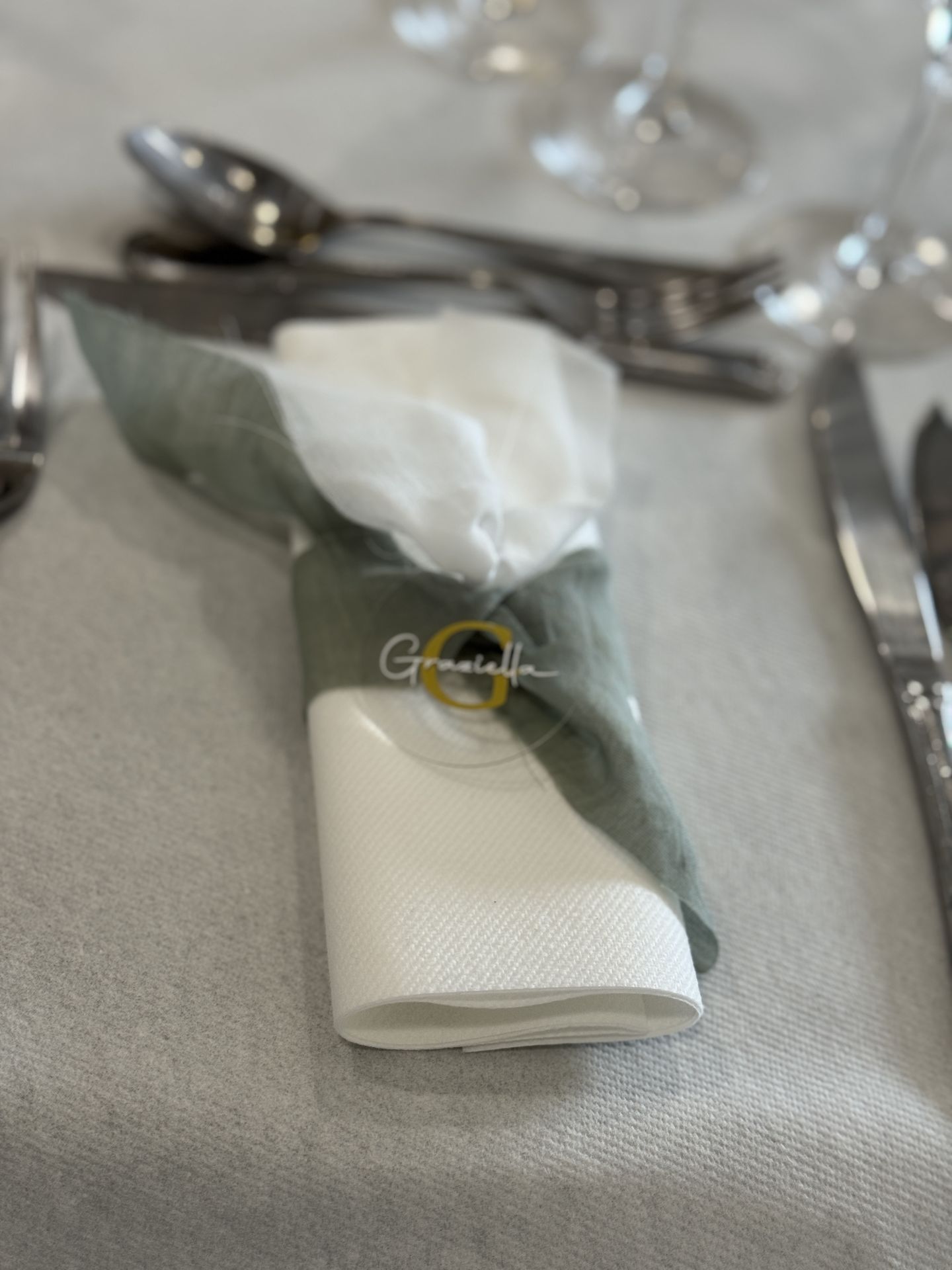 Mariage Domaine de Marin serviette blanche noeud vert sauge marque place personnalisé plexis blanc et dorée