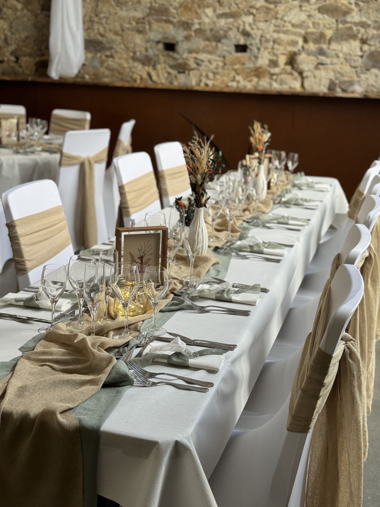 Mariage Domaine de Marin table blanche chemin de table vert sauge et sable noeud de chaise sable menu cadre bois naturel vase fleurs sèches