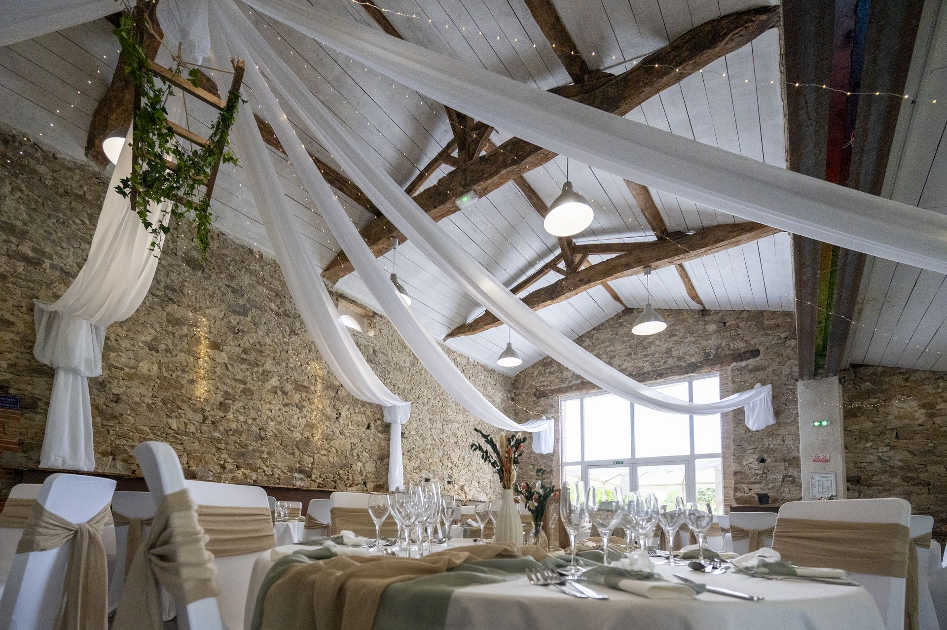 Mariage Domaine de Marin plafond tentures blanches leds structure bois lière table blanche vert sauge et sable