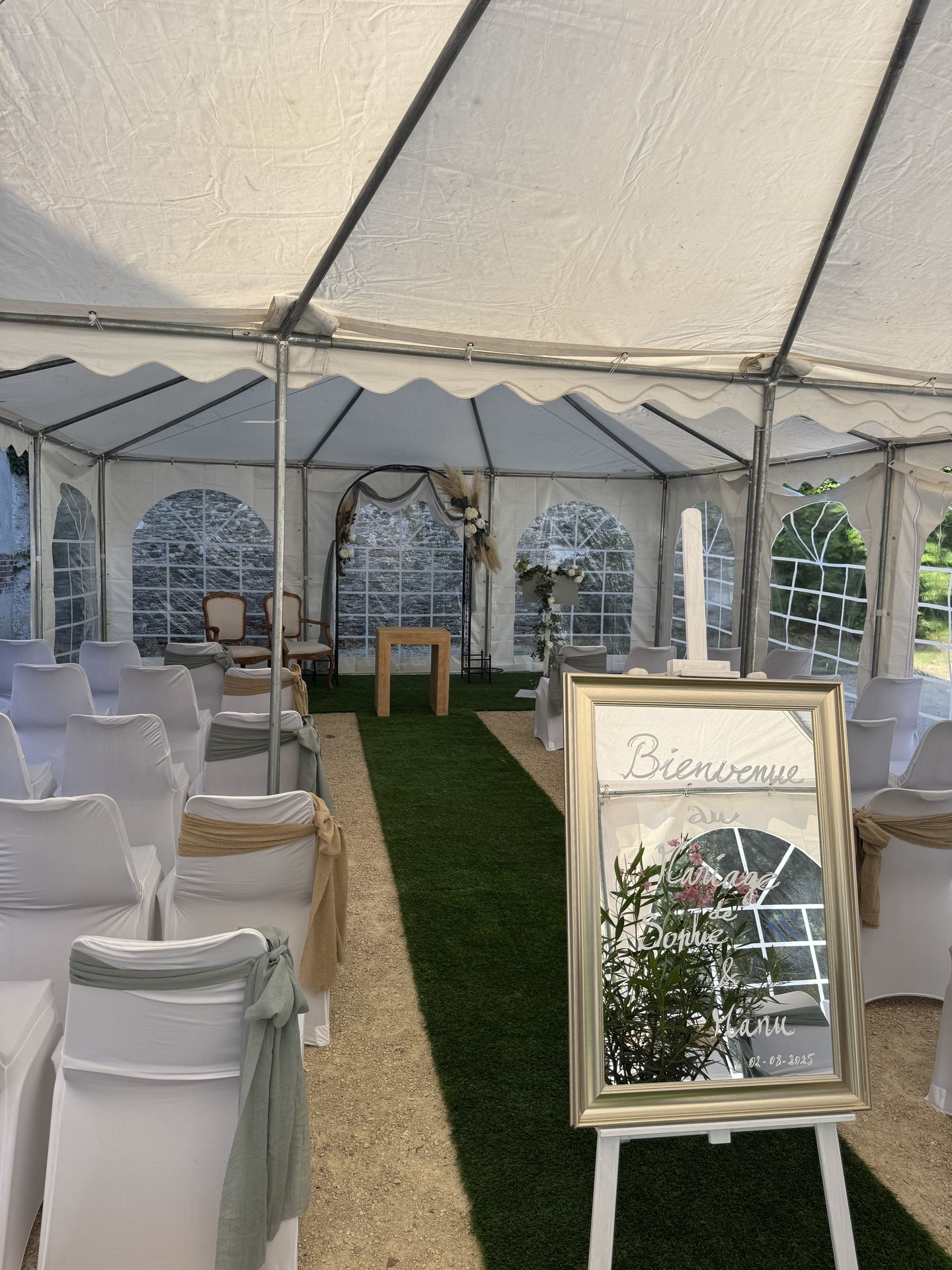 Mariage Salle des Fêtes cérémonie laique barnum panneau bienvenue dorée miroir chaise blanche noeud sablearche arrondi pupitre blanc feuillage