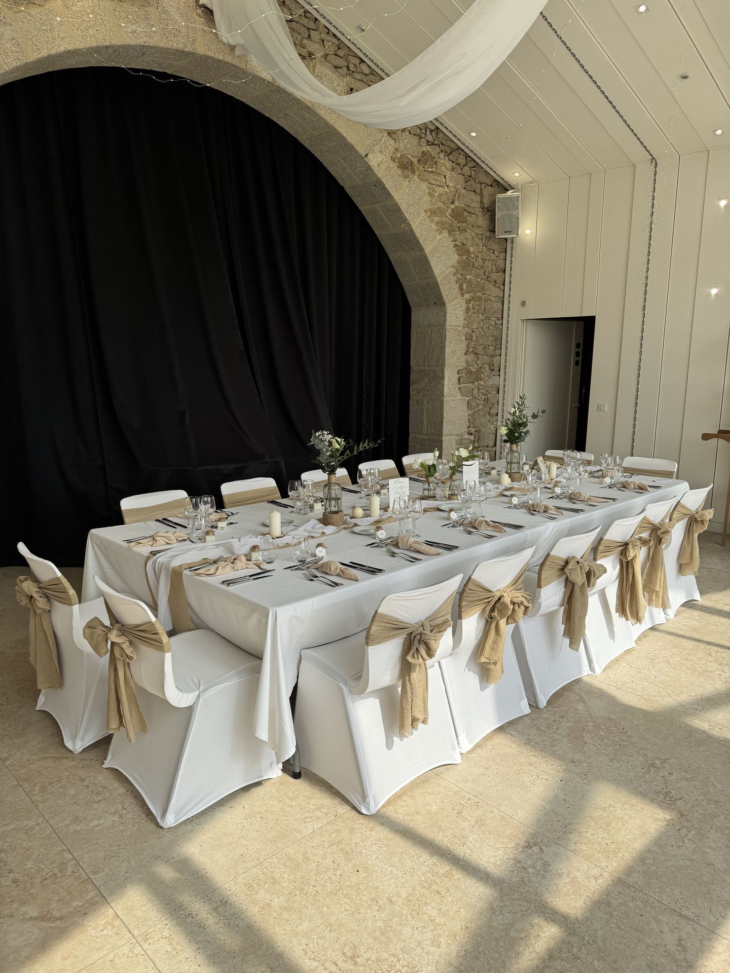 Mariage La Vallée de la Roche table blanche noeud de chaise sable tentures fleurs bougies