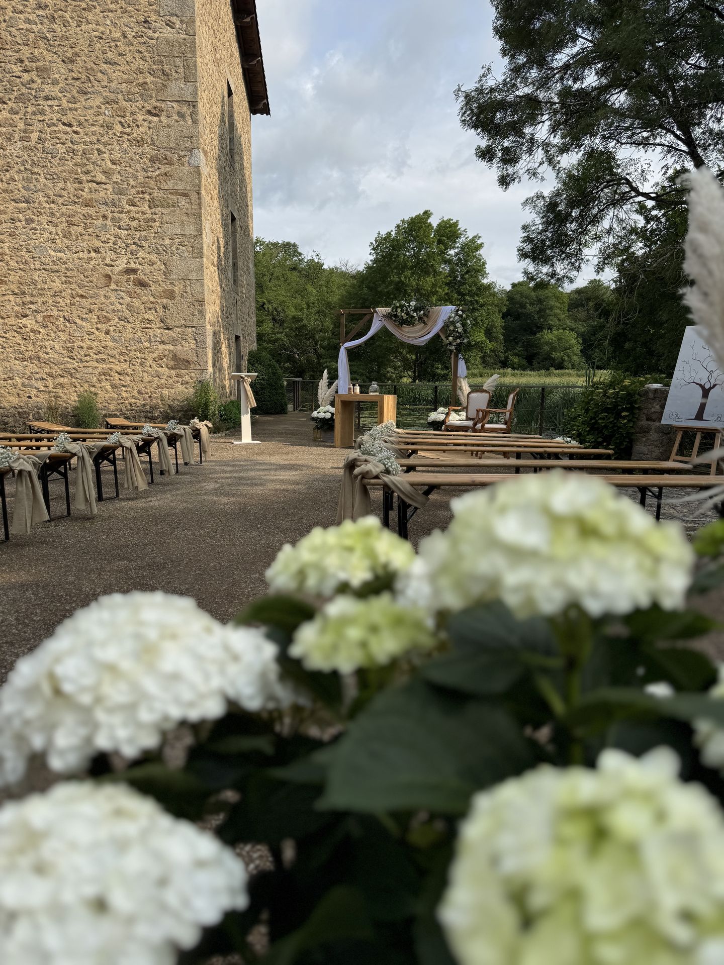Mariage La Vallée de la Roche cérémonie laique banc en bois noeud sable fleurs arche en bois tissu beige blanc feuillage