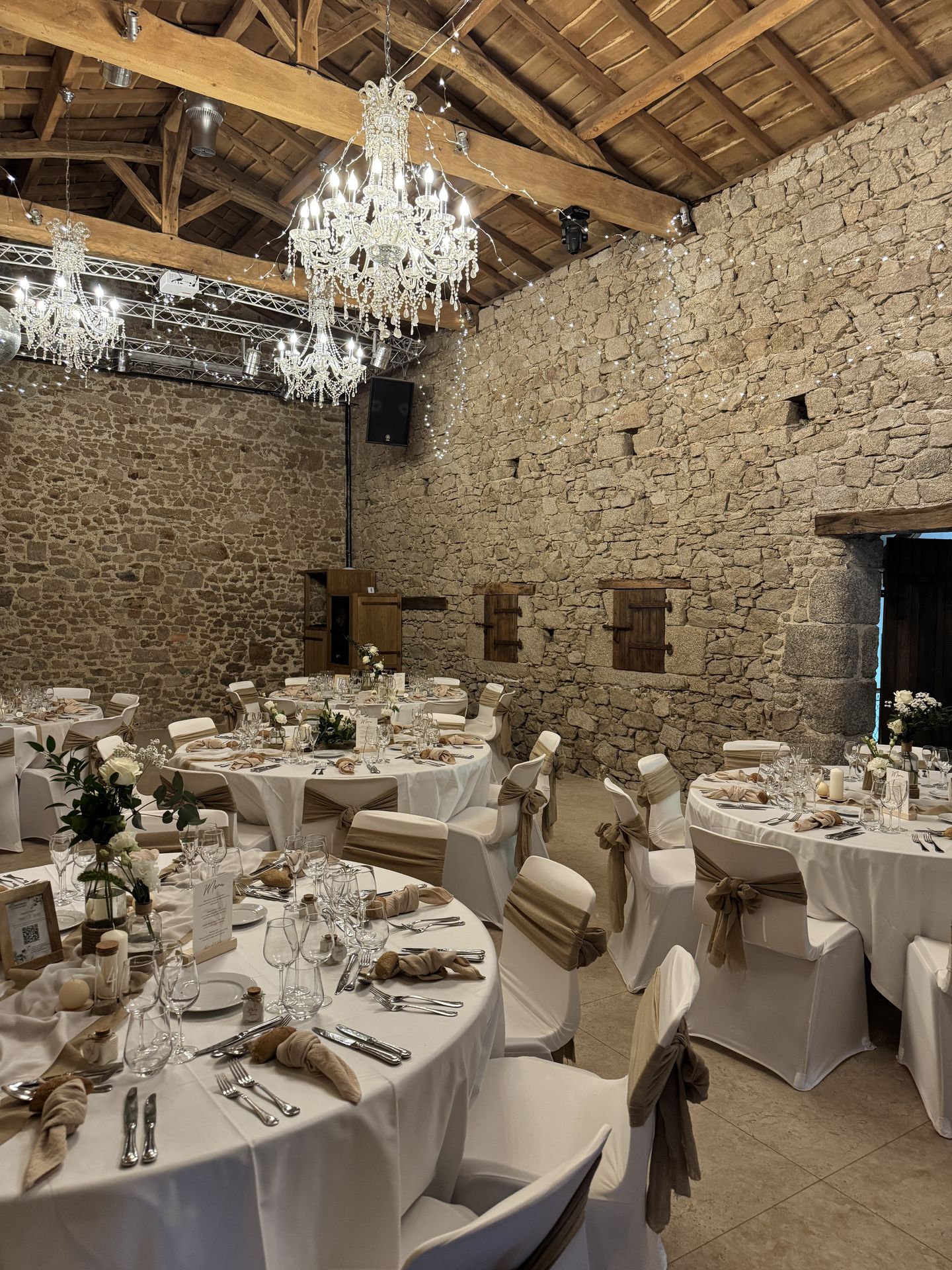 Mariage La Vallée de la Roche salle intérieur table blanche noeud de chaise sable fleurs plafond ciel étoilé