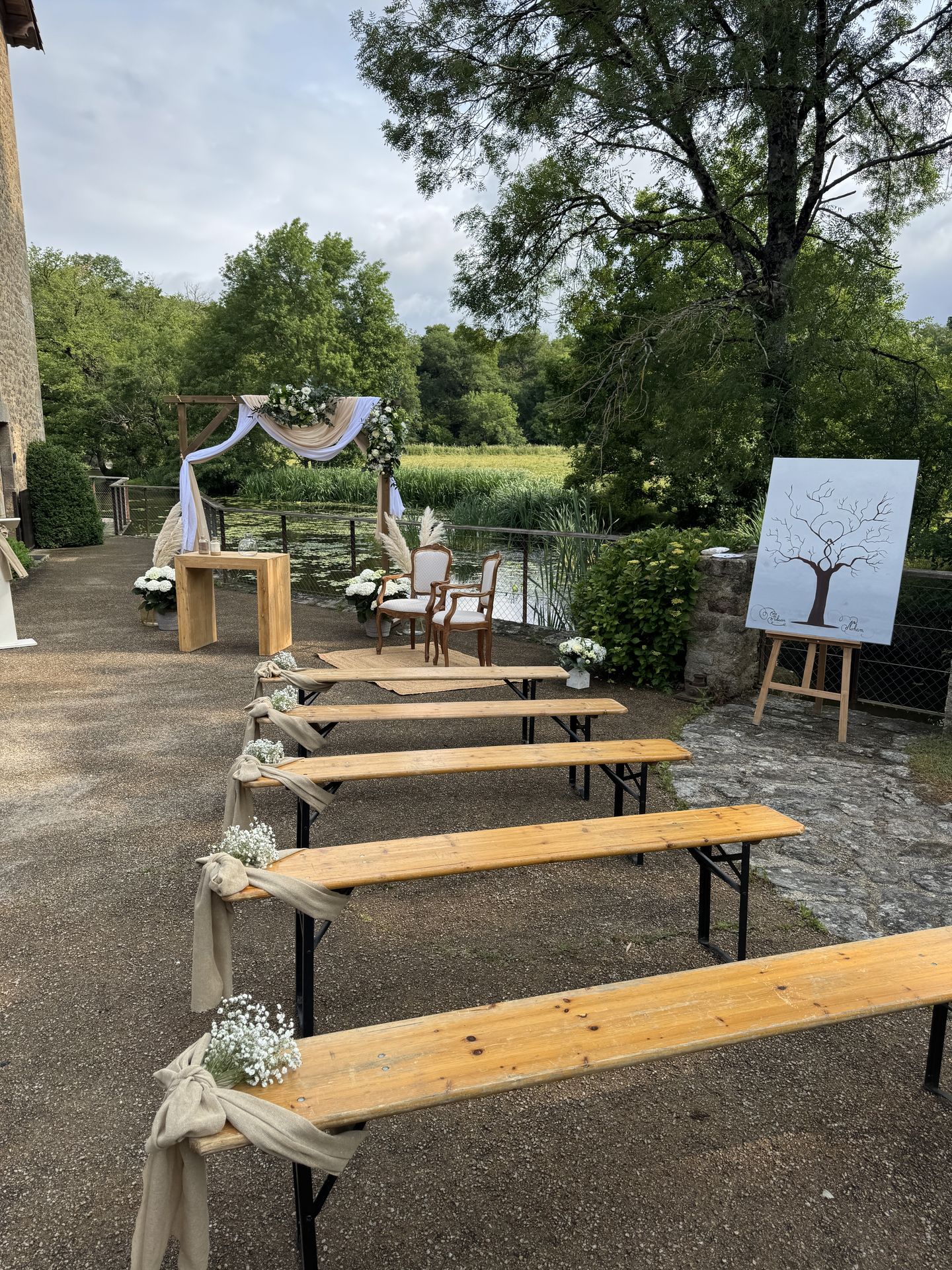 Mariage La Vallée de la Roche cérémonie laique banc en bois noeud sable fleurs arche en bois tissu beige blanc feuillage tableau peinture arbre