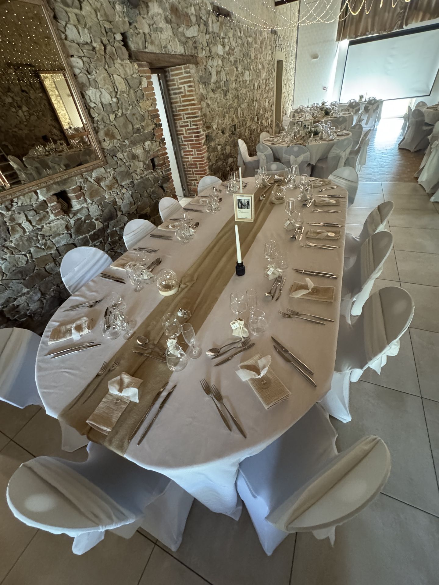 Mariage Domaine de Marin table blanche chemin de table sable bougies vase fleurs cadre en bois photo mariés