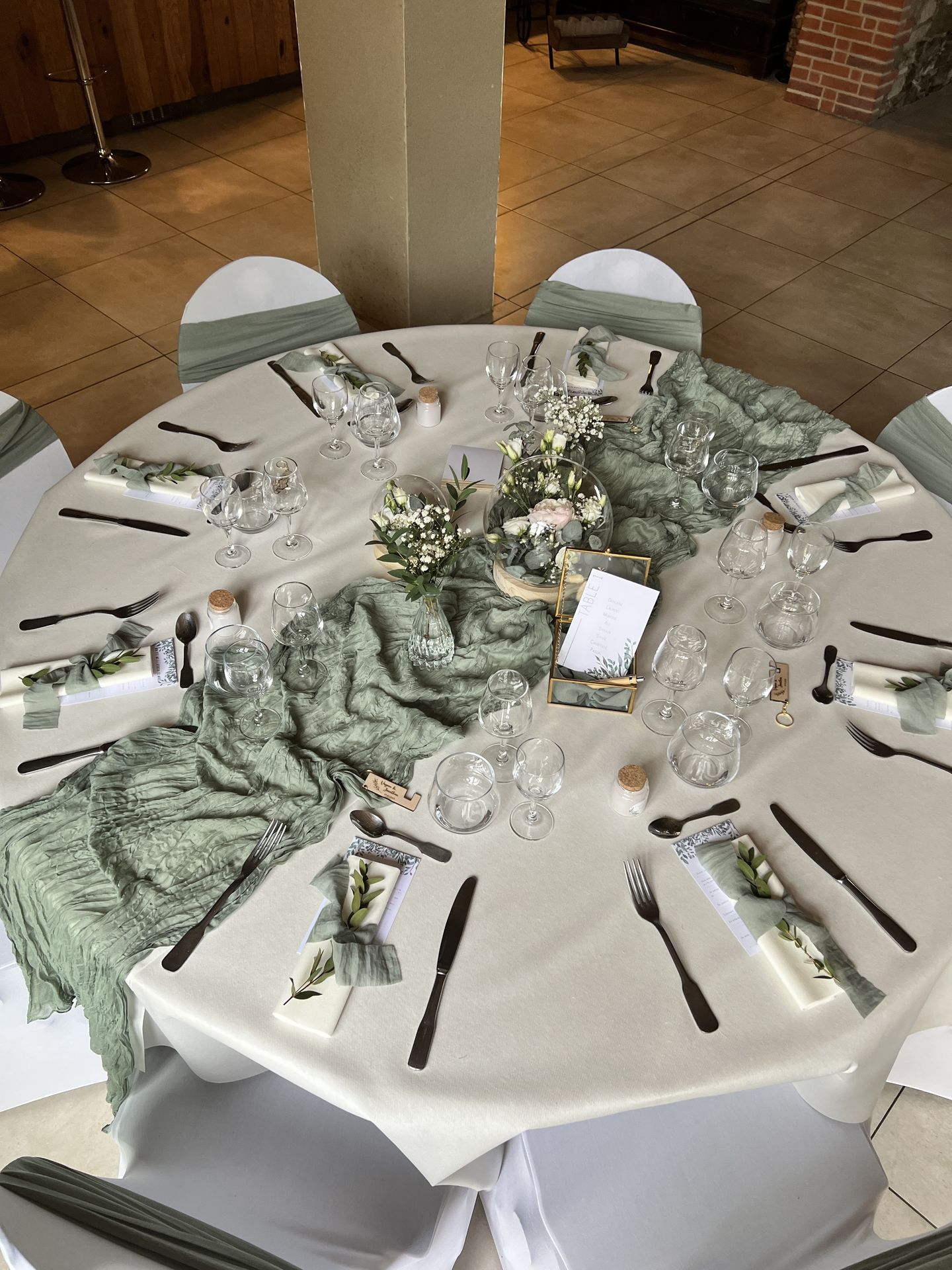 Mariage Domaine de Marin table blanche chemin de table vert sauge boite dorée cube menu de table vase composition florale