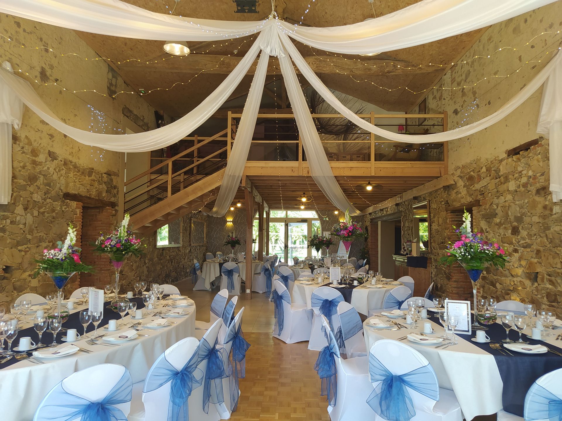 Mariage Domaine de Marin plafond tentures blanches et leds table blanches et bleu noeud de chaise bleu