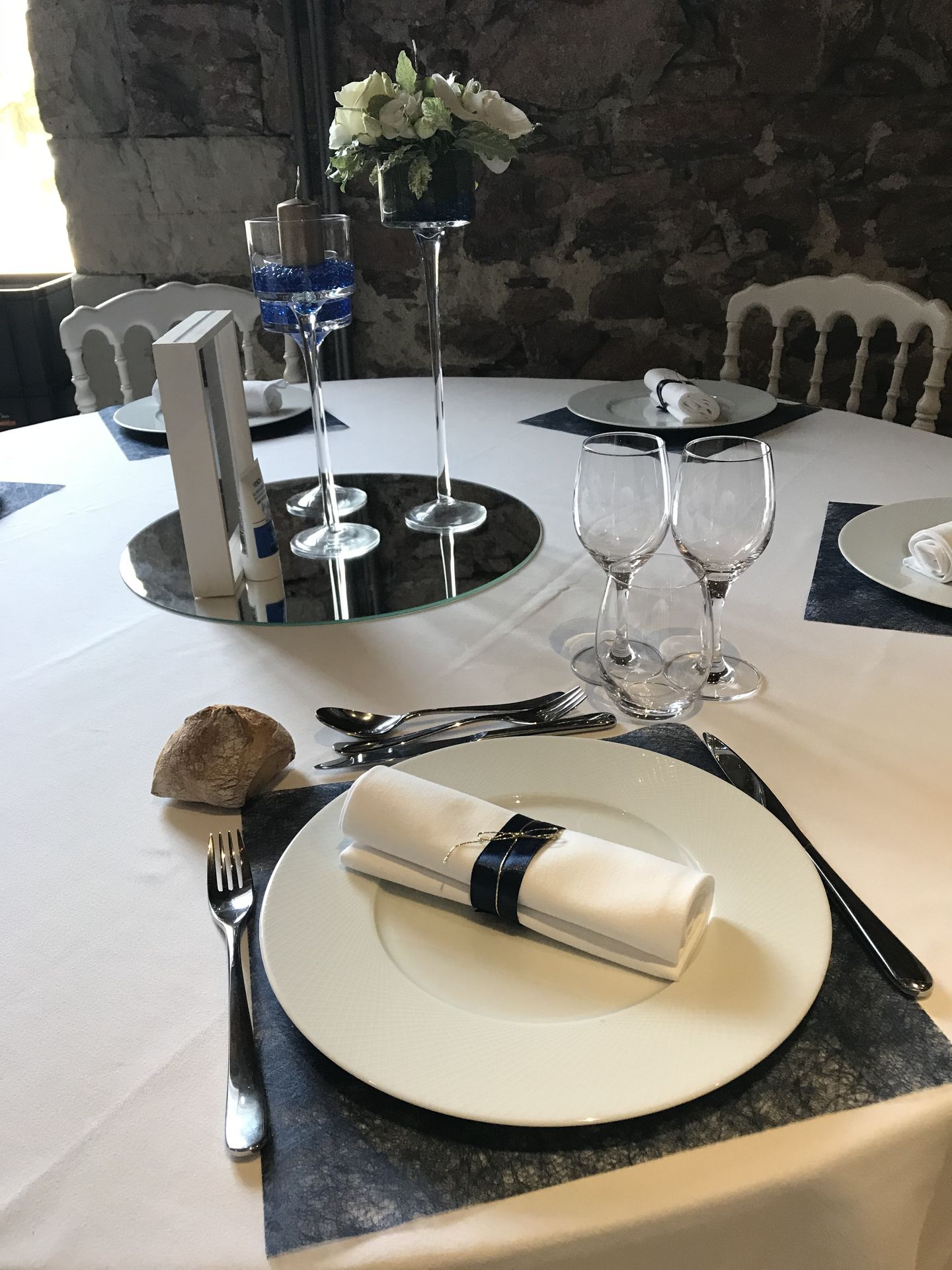 Mariage Château de la Galissonnière dessous de table bleu marine serviette blanche et noeud bleu marine centre de table miroir rond vase fleurs cadre blanc en bois menu de table