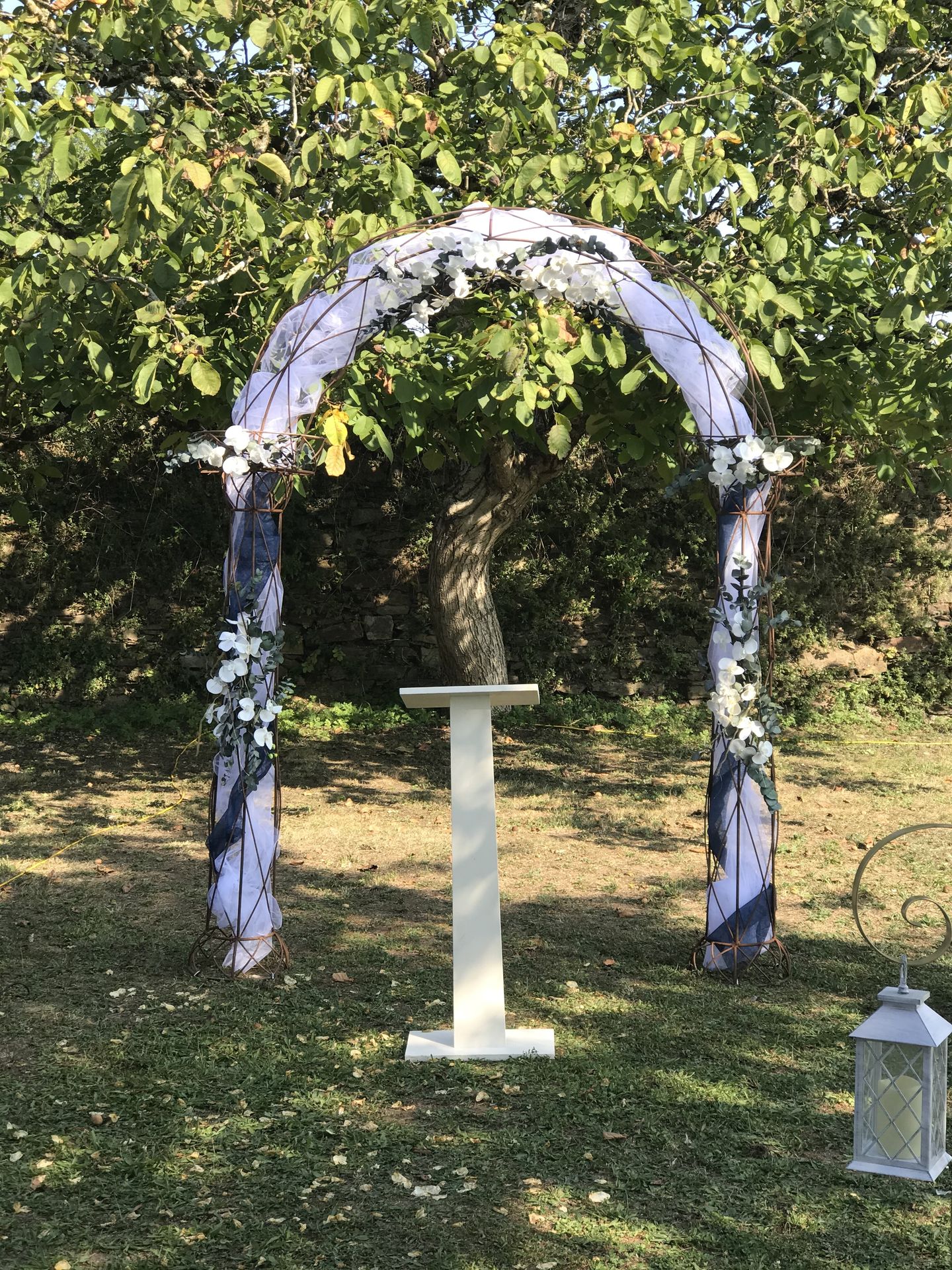 Mariage Château de la Galissonnière arche en métal tissu blanc et bleu marine composition florale blanche