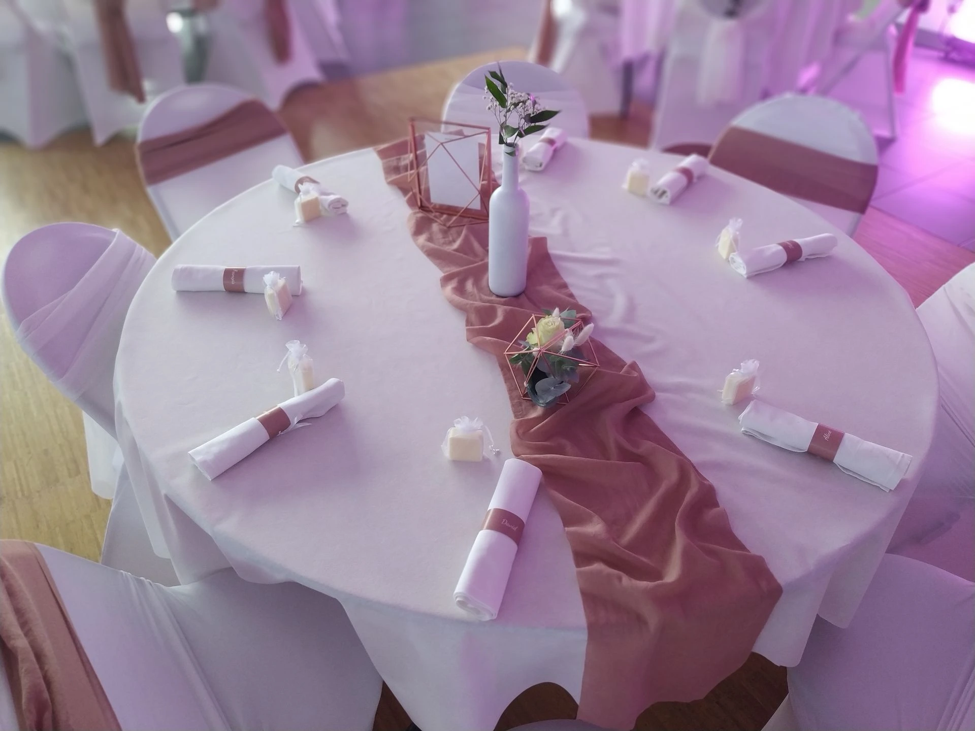 Mariage Salle des Fêtes centre de table vieux rose structure rose et fleurs cadre rose menu de table nom de table bouteille blanche