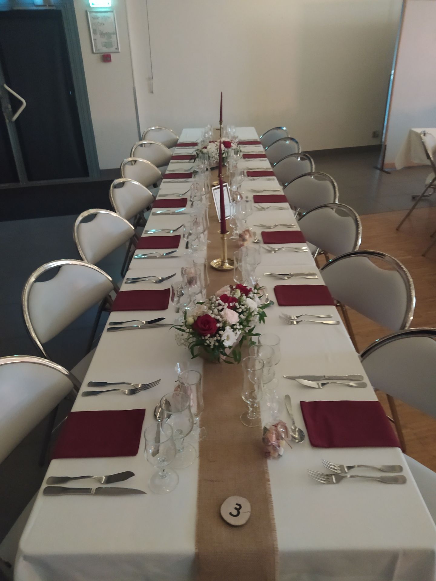 Mariage Salle des Fêtes table blanche chemin de table sable serviette bordeaux composition florale bougie dorée et bordeaux rondin de bois chiffres