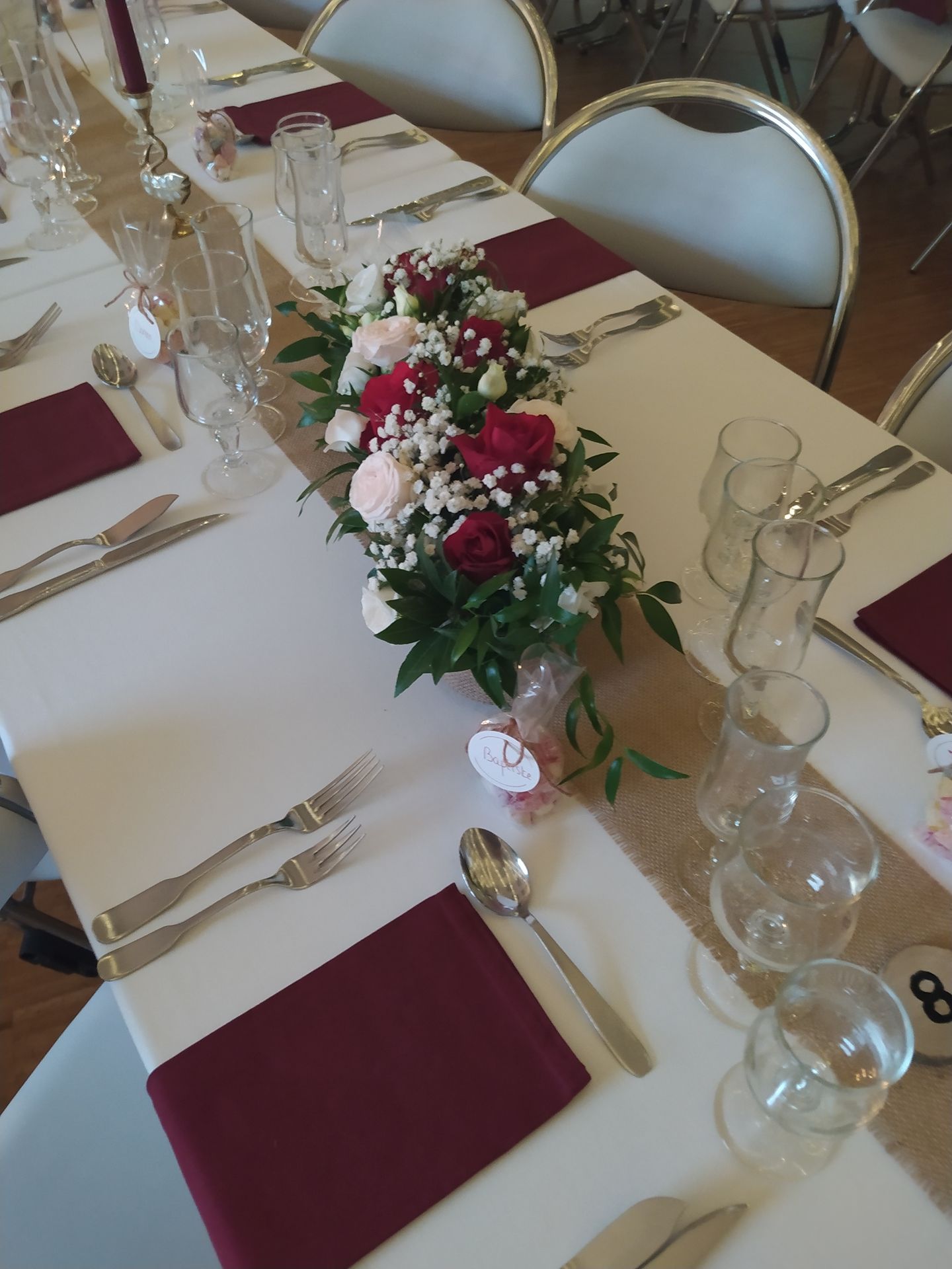 Mariage Salle des Fêtes chemin de table sable serviette bordeaux composition florale cadeaux invités dragée bougie dorée bordeaux