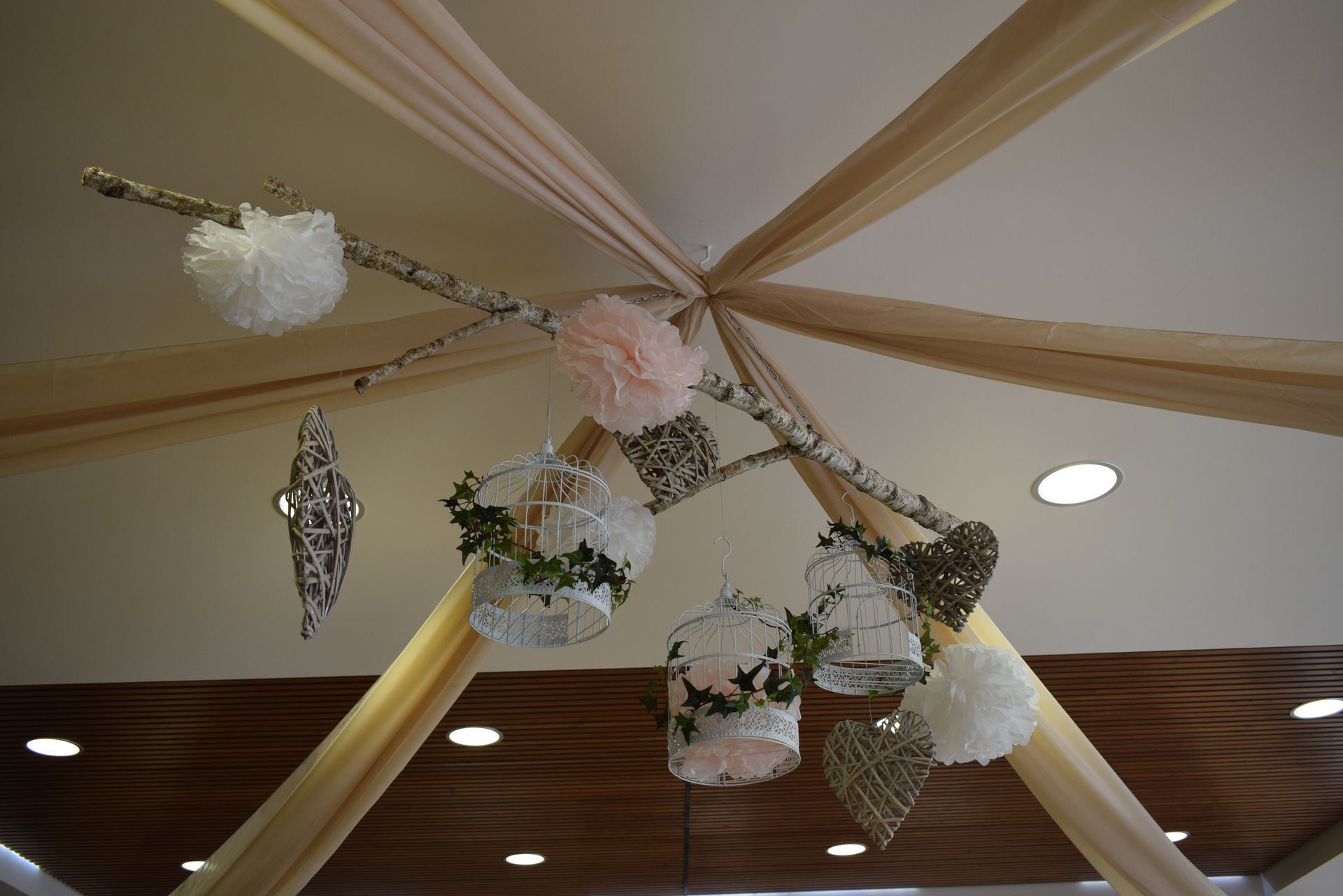 Mariage Salle L'Arc en Ciel plafond tentures sables structure bois cage blanche lière fleurs rose et blanche