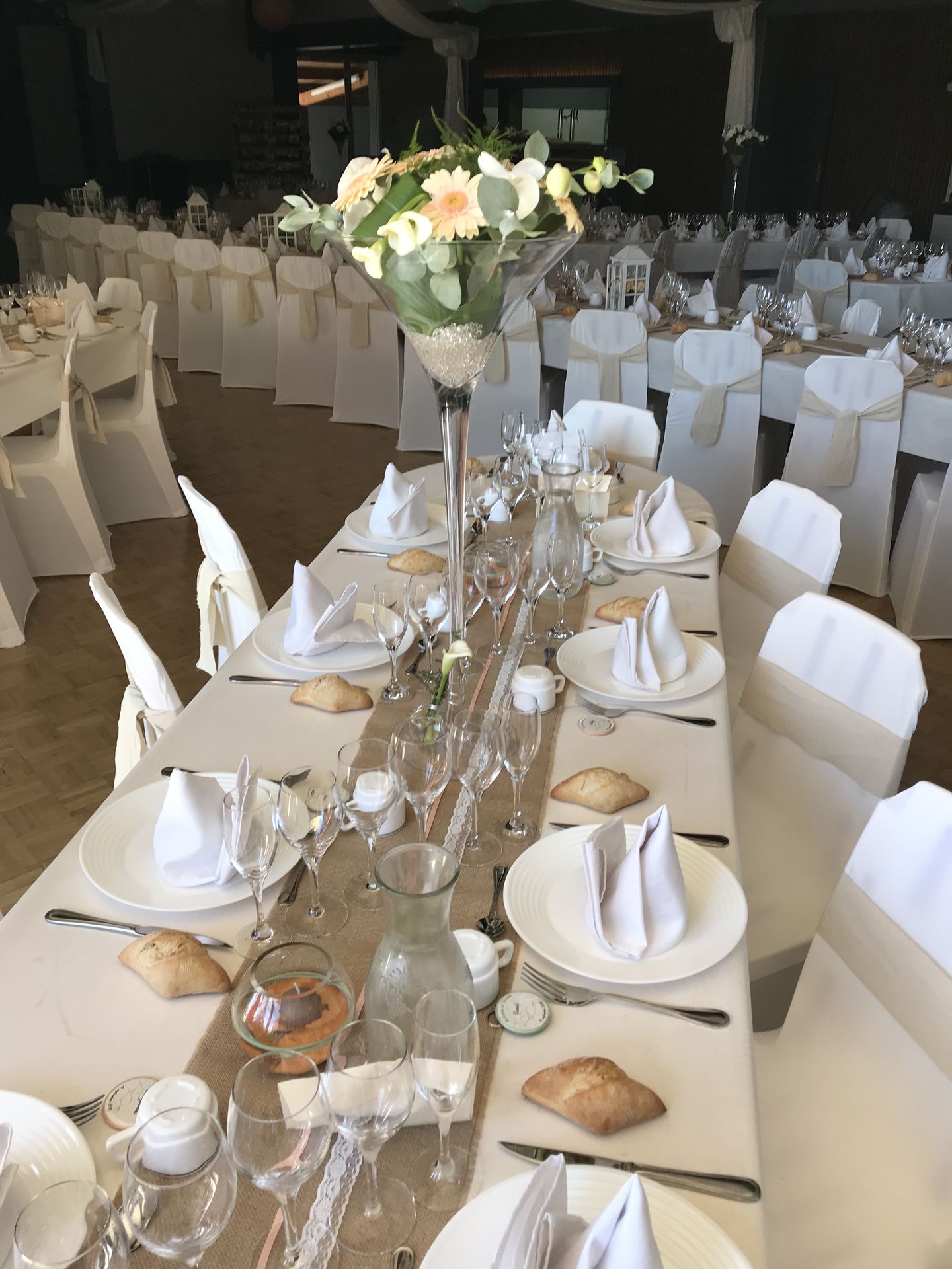 Mariage Salle L'Arc en Ciel table blanche chemin de table sable vase haut composition florale