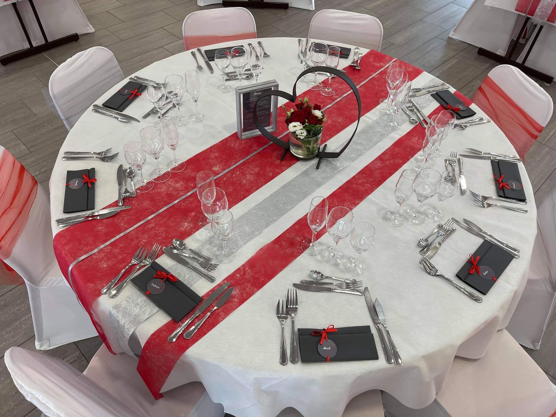 Mariage Salle du Bocage table blanche chemin de table rouge grise noeud de chaise rouge et grise coeur en métal argent cadre blanc en bois menu de table