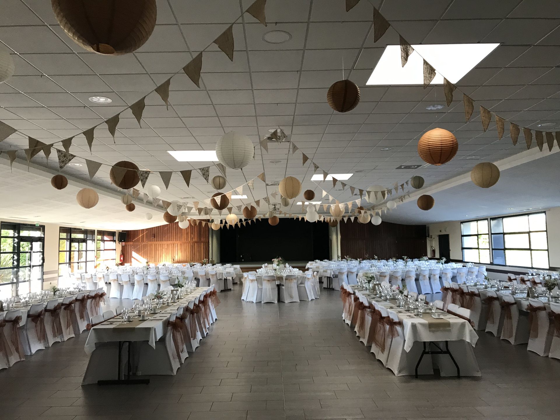 Mariage Salle du Bocage plafond guirlande fanion boule chinoise blanche beige marron table blanche chemin de table sable noeud de chaise marron