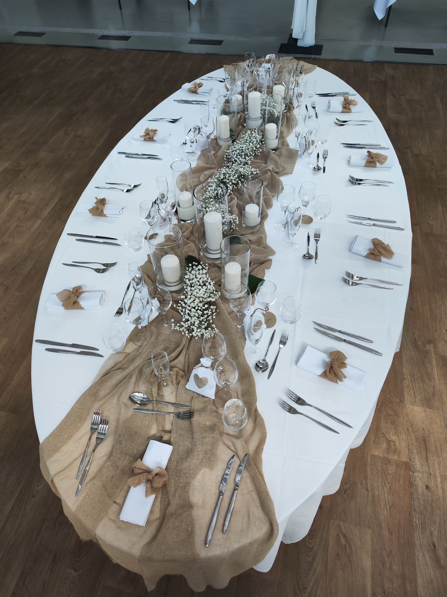 Mariage La Barbinière table blanche chemin de table sable noeud sable serviette vase bougie blanche composition florale blanche