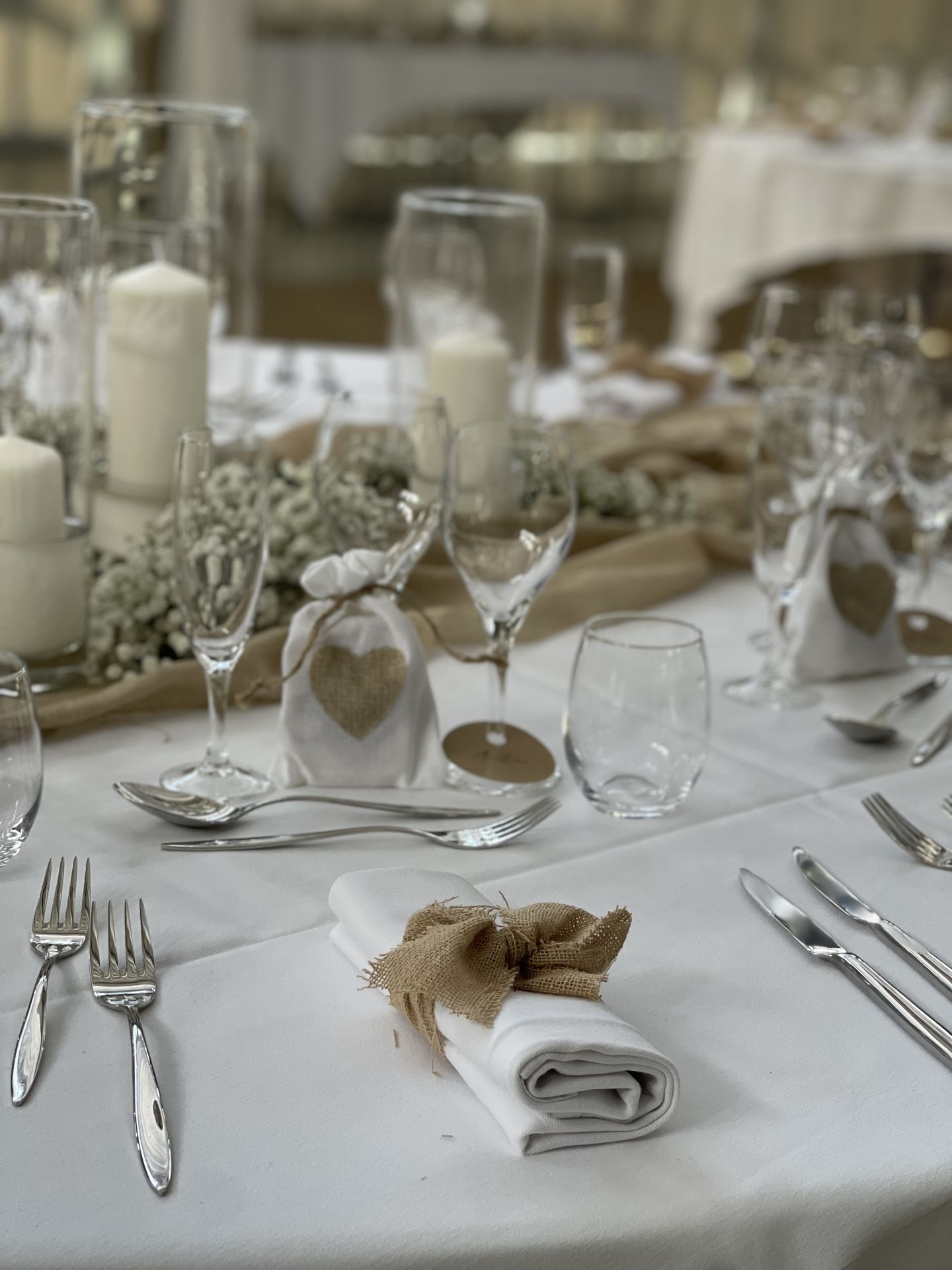Mariage La Barbinière table blanche chemin de table sable noeud sable serviette vase bougie blanche composition florale blanche